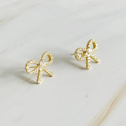 Elegant gold bow stud earrings crafted from sterling silver, adorned with cubic zirconia, perfect for any outfit