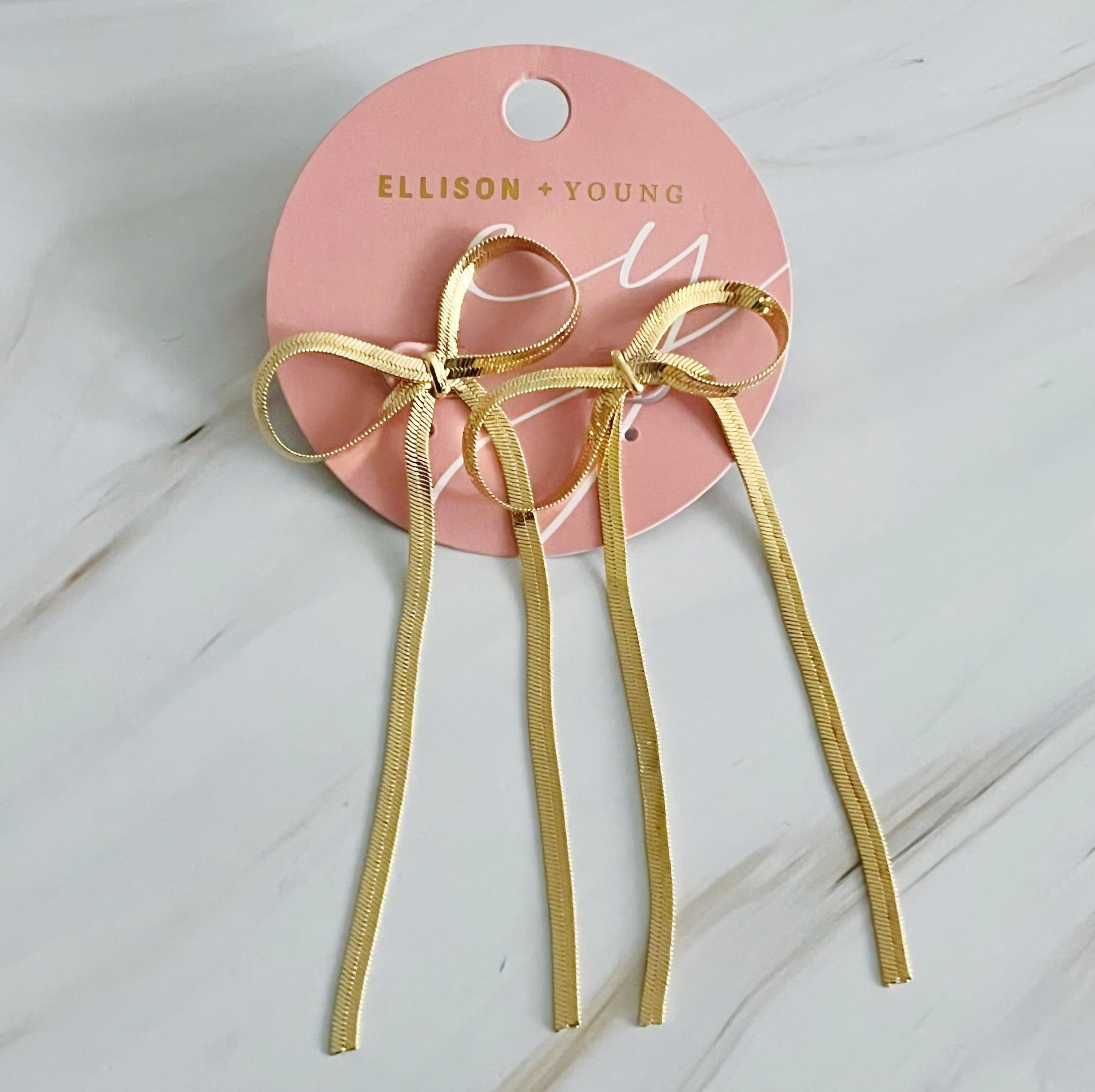 Elegant long drop bow earrings, 18k gold plated, perfect for a chic look. Dimensions: approximately 1.5" x 3".