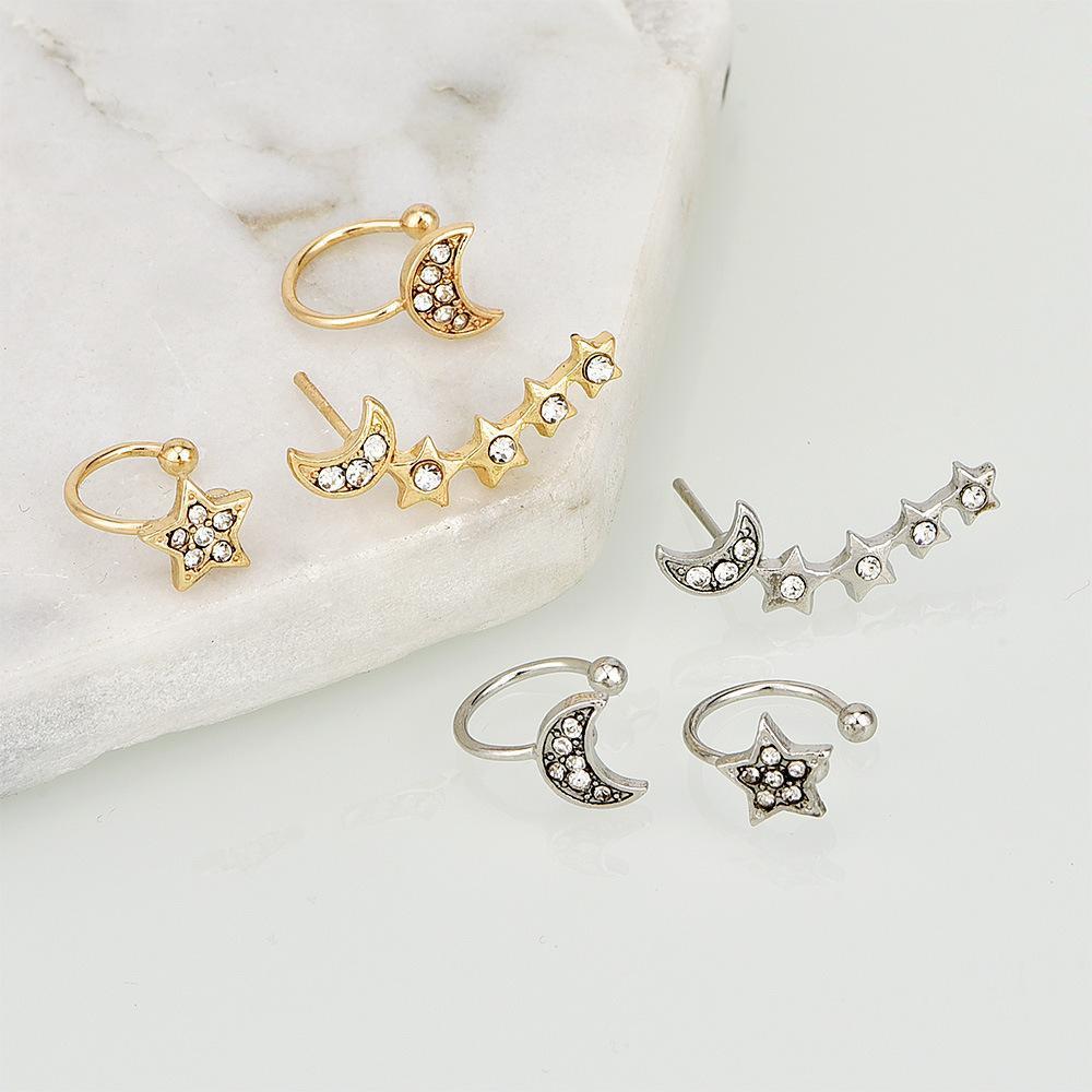 Set of three earrings with star and moon designs, including two cuffs and one crawler for a stylish asymmetrical appearance.