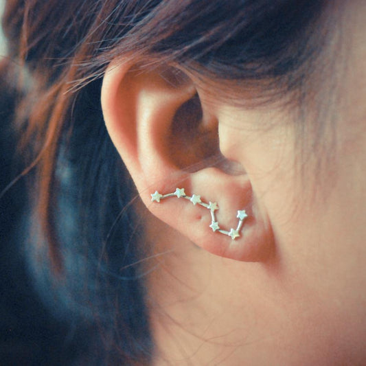 A woman wearing star-shaped earrings made of high-quality zinc alloy, showcasing a stylish accessory.