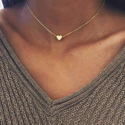  A woman showcases a gold heart necklace, made of highquality zinc alloy, with a heart pendant and adjustable length