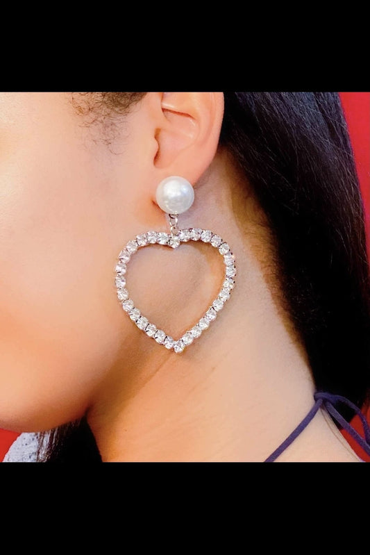  A woman wearing silver heart-shaped drop earrings made of
high-quality zinc alloy, perfect for special occasions and casual
wear