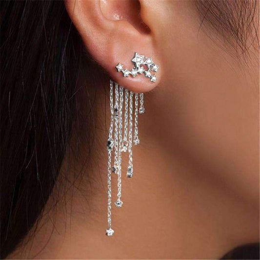  A woman wears silver star-shaped stud earrings, showcasing their versatility for everyday or evening styles.