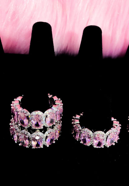 Three pairs of pink diamond earrings arranged on a black
background, highlighting their exquisite design and sparkle