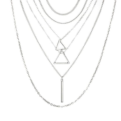 A layered collection of silver necklaces with two triangles, one vertical bar, two chokers, and one long adjustable chain