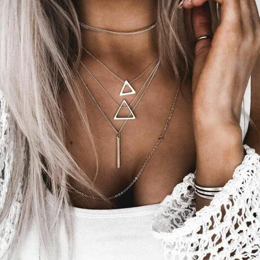A woman in a white top models a multi-layered necklace with triangles and chokers, featuring an adjustable zinc alloy chain