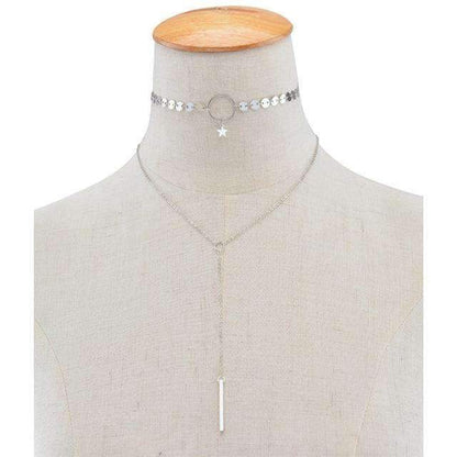  A silver two-layer necklace on a mannequin neck features a star and circle choker with a long adjustable lariat.